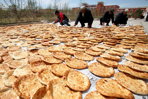 People air local food Nang (baked crusty pancake) before transporting them to quake-hit Yushu in Hami, Northwest China’s Xinjiang Uygur autonomous region, April 18, 2010.