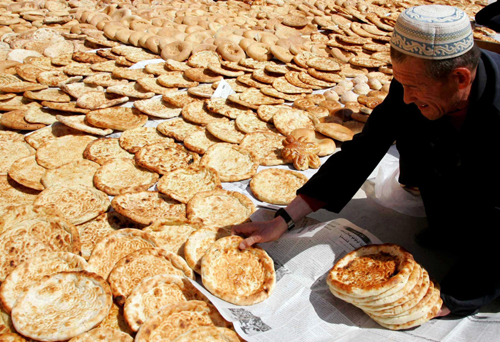 An Uygur man airs local food Nang (baked crusty pancake) before transporting them to quake-hit Yushu in Hami, Northwest China’s Xinjiang Uygur autonomous region, April 18, 2010. 
