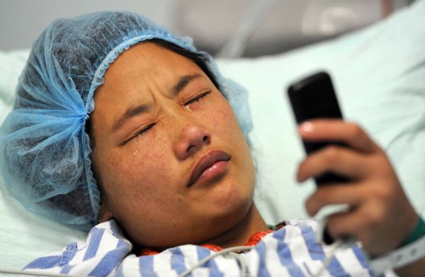 Qiuqu injured in the quake makes phonecall to their parents after meets her seriouly-injured brother Gajiao at the Huaxi Hospital Affiliated to Sichuan University in Chengdu, southwest China's Sichuan Province, April 18, 2010. 