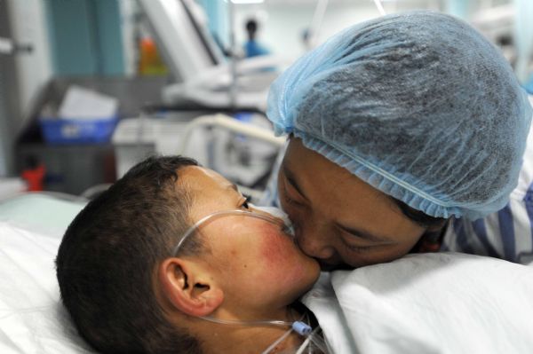 Injured Qiuqu kisses her younger brother Gajiao when they meet for the first time after transfered from the quake-hit site for medical treatment at the Huaxi Hospital Affiliated to Sichuan University in Chengdu, southwest China's Sichuan Province, April 18, 2010.