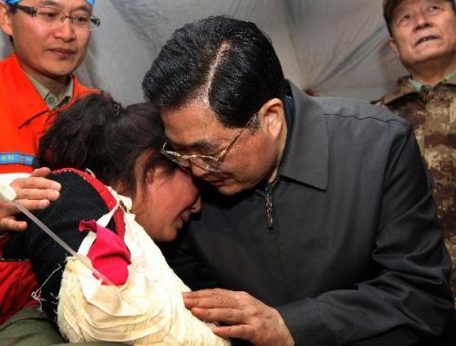 Chinese President Hu Jintao (R front) gives a hug to injured student Zhoema of Tibetan ethnic group during his visit to those injured in the quake receiving treatment at a stadium in the Tibetan Autonomous Prefecture of Yushu, northwest China&apos;s Qinghai Province, April 18, 2010. [Xinhua] 