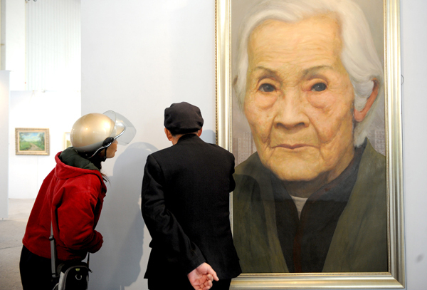 Visitors view a painting at the 3rd China Culture and Art Expo in Weifang, Shandong Province, April 18, 2010. 