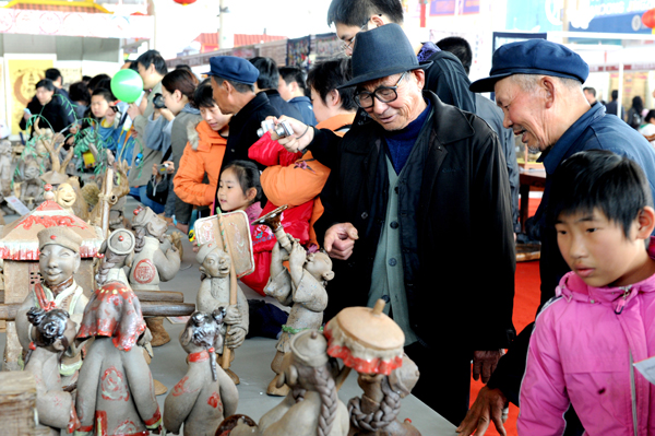 Visitors view pottery articles at the 3rd China Culture and Art Expo in Weifang, Shandong Province, April 18, 2010.