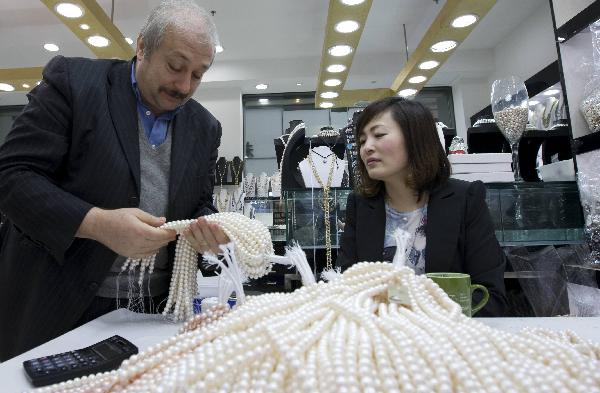 A businessman buy pearl necklaces at the 7th China International Pearl Festival kicked off in Huadong International Jewelry City, a jewelry shopping center, in Shanxiahu Township in Zhuji City, east China's Zhejiang Province, April 18, 2010. (Xinhua) 