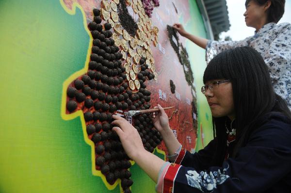 Photo taken on April 19, 2010, shows workers pasting a tea map in the Badachu Park in Beijing. Various kinds of tea leaves are pasted to the particular regions where they grow on a 20-sq m China map. The tea map will make its debut at the 9th China Gardening and Tea Culture Festival on April 27. [Xinhua] 