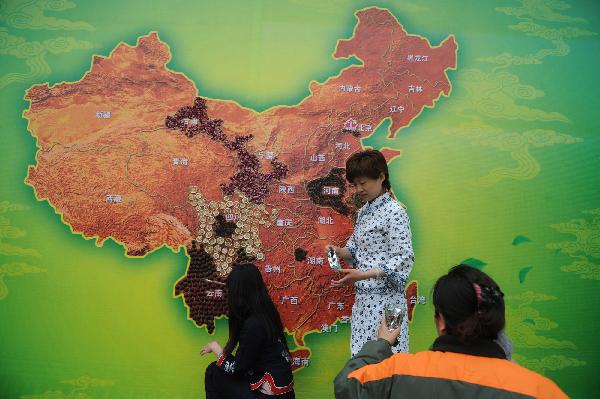 Photo taken on April 19, 2010, shows workers pasting a tea map in the Badachu Park in Beijing. Various kinds of tea leaves are pasted to the particular regions where they grow on a 20-sq m China map. The tea map will make its debut at the 9th China Gardening and Tea Culture Festival on April 27. [Xinhua]