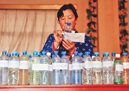 Tian Guirong tags bottles containing samples she and her team collect from different water sources around the rural areas in Henan province.[China Daily]