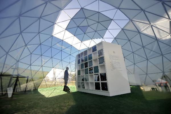  A man listens to music inside a solar-powered environmental structure at the National Mall in Washington D.C., the United States, April 19, 2010. A massive Climate Rally will be held in the US capital on Sunday to commemorate the 40th anniversary of Earth Day. [Xinhua]