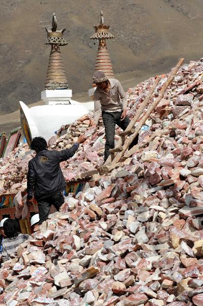 Two local people refit the destroyed Gyanak Marnyi stones, about 2 kilometers from the quake-hit Gyegu Town of Yushu Tibetan Autonomous Prefecture of northwest China's Qinghai Province, April 19, 2010.(