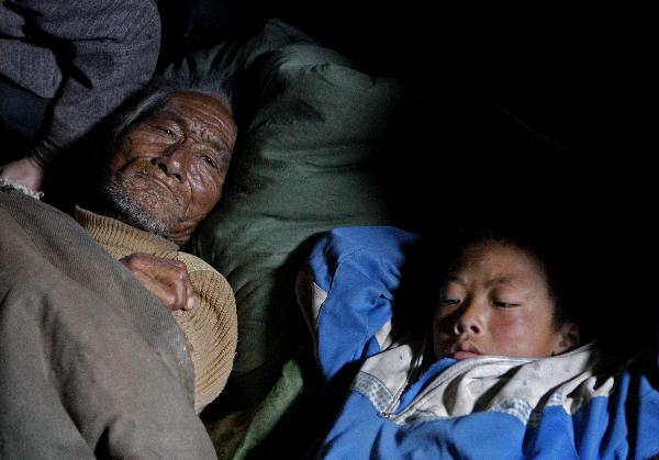 Two injured rest in an aircraft heading to Xining for treat in Yushu, northwest China's Qinghai Province, April 19, 2010. Civil aircrafts and military planes were put into operation for rescue team and supply transportation after the quake hit Yushu County.