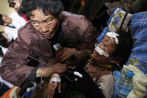 Cewn Degyi(R) rests in an aircraft heading to Xining for treat in Yushu, northwest China's Qinghai Province, April 19, 2010. Civil aircrafts and military planes were put into operation for rescue team and supply transportation after the quake hit Yushu County. 