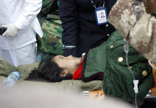 Nine-year-old Danzhen Qiusong is carried to an aircraft heading to Xining for treat in Yushu, northwest China's Qinghai Province, April 19, 2010. Civil aircrafts and military planes were put into operation for rescue team and supply transportation after the quake hit Yushu County.