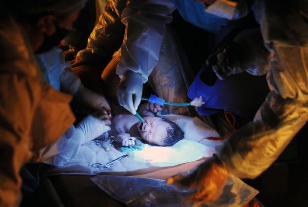 Nurses take care of a newborn baby at a makeshift shelter in Yushu County, northwest China's Qinghai Province, on April 19, 2010. 
