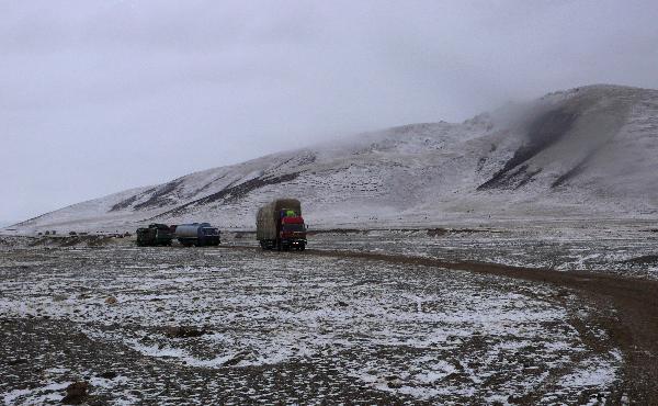 Running on the snow-covered plateau, a long motorcade of cargo vehicles transport quake-relief materials to Yushu, northwest China's Qinghai Province, April 19, 2010. The quake-relief materials were continuously transported to the disaster areas despite the snowfall and frozen road surface. 