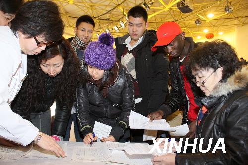 College staff were dealing with foreign students' registration forms in Beijing. [Xinhua Filephoto]