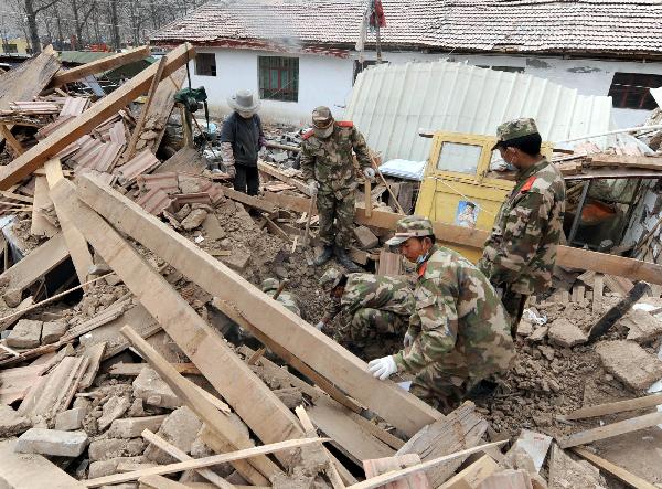 Military officials and soldiers of Gansu Armed Police Contingent help quake victims to clear ruins in Yushu County, northwest China's Qinghai Province, April 20, 2010. More than 8,000 Chinese PLA members and armed police military officials and soldiers help quake victims to clear ruins and rebuild their homes these days. 
