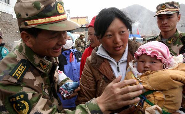 A medical worker of the Chinese public security frontier defense troop gives a baby a health check in Gyegu Town of Yushu County, northwest China's Qinghai Province, April 20, 2010. The quake-jolted area in Qinghai was attacked by a hailstorm Tuesday, which hampered the disaster relief efforts.