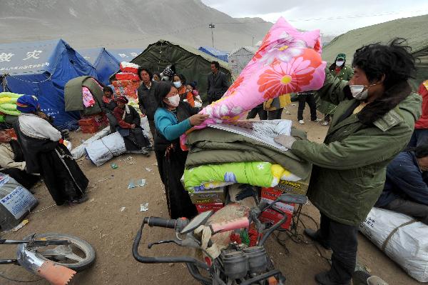 Quake victims receive quake-relief quilts and foods in Yushu County, northwest China's Qinghai Province, April 20, 2010. Civil administration departments try their best these days to distribute quake-relief materials including tents, quilts and foods to ensure quake victims' daily necessities.