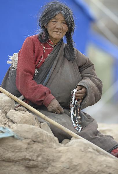 An elder woman of Tibetan ethnic group prays at the quake-devastated Zhaxi Datong Village, in Gyegu Town, Yushu County, northwest China's Qinghai Province, April 19, 2010. Zhaxi Datong Village is the worst-hit area during the April 14 quake in Qinghai. It has been mostly razed to the ground and 120 of the total about 670 villagers here lost their lives.