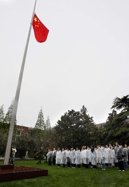 Students of Fudan University watch as Chinese national flag is lowered to half-mast in Shanghai, east China, April 21, 2010. Students of Fudan University attended a mourning ceremony early Wednesday to pay respect to the victims of Yushu earthquake.