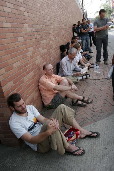 Passengers queue for tickets outside an airline agency in Kathmandu, capital of Nepal, April 22, 2010. Hundreds of foreign passengers stranded in Kathmandu are hopeful of flying home after European governments temporary reopened the airports. The closure of the European airspace casued by the Icelandic volcanic ash has trapped hundreds of thousands of passengers around the world, crippling airlines. [Bimal Gautam/Xinhua] 