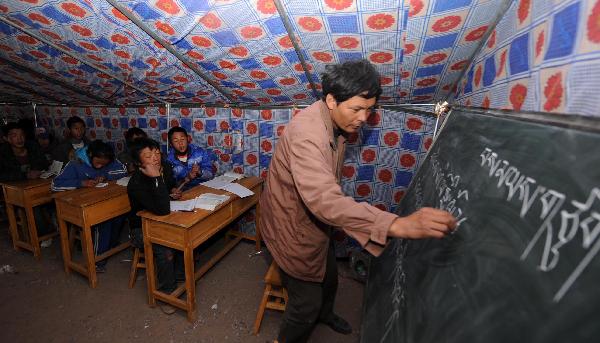 Isun and his students have a class in a tent in Yushu, northwest China's Qinghai Province, April 20, 2010. Lots of students have been transferred to temporary tents in Yushu to continue their study. 