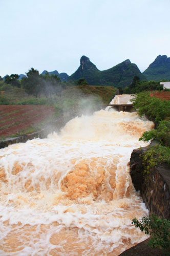 Triggered by torrential rain over the past few days, a raging torrent swept through Gongcheng Autonomous Prefecture in Guangxi, April 22, 2010. [Xinhua]