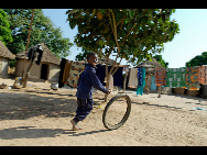 And Kanda, too is recovered. He proudly presents his favourite toy, an old bicycle wheel that he pretends is his motorbike. The malaria pills tasted bitter he thought. But he knows that taking them has made him feel better.  'When I am big, I want a real motorbike', he laughs - and runs off to play with his friends. [MSF/Barbara Sigge]