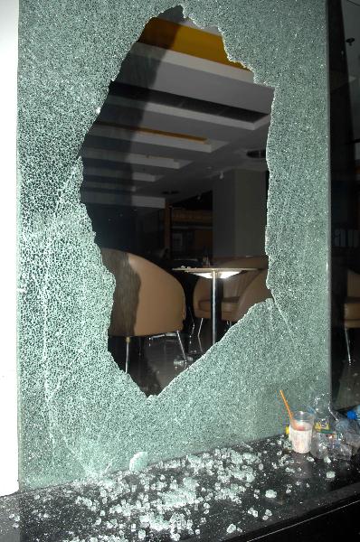 The broken window of a cafe shop is seen after an explosion on Silom Road in the financial district of central Bangkok,capital of Thailand,April 22,2010.[Shi Xianzhen/Xinhua]