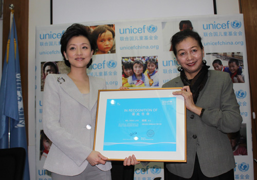 Dr. Yin Yin Nwe, UNICEF China Representative, presents a certificate to Yang Lan.