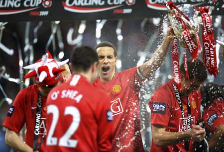Manchester United's captain Rio Ferdinand (C) celebrates with the trophy after winning the English League Cup final soccer match against Tottenham Hotspur at Wembley Stadium in London March 1, 2009.