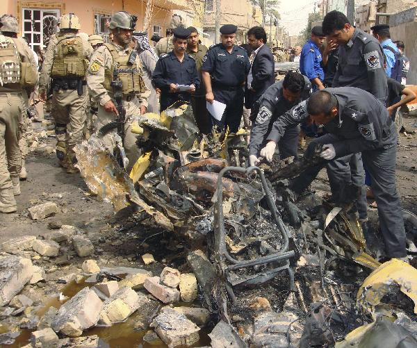 Iraqi personnel from the Explosive Ordnance Disposal (EOD) unit inspect a wreckage at the scene of a bomb blast in Hurriya District, northwestern Baghdad April 23, 2010. The toll from several bomb blasts that struck Shiite areas of the Iraqi capital on Friday reached 52 killed and 106 wounded, an Interior Ministry source said. [Xinhua/Reuters Photo]