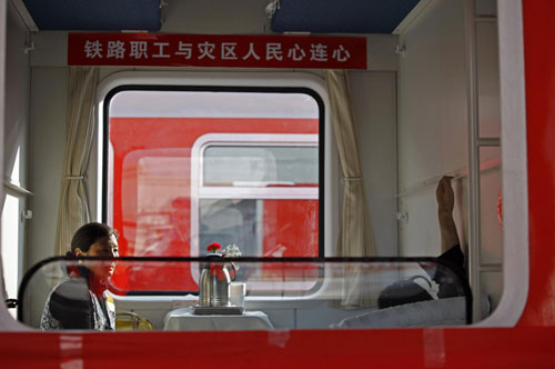 Accompanied by his family members, an injured quake victim from Yushu lies in a carriage of a train bound for Xi'an to receive medical treatment, April 24, 2010. [Photo/Xinhua]