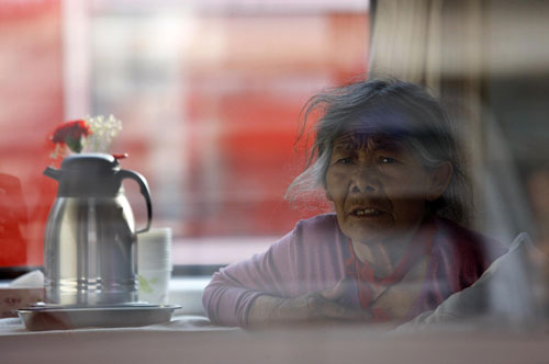 An elderly injured quake victim from Yushu looks out a train window as she was being transferred to Xi'an, capital of Shaanxi province, to receive medical treatment on Saturday, April 24. [Photo/Xinhua]