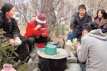 Tse Tashi, 55 (second right) and his family enjoy breakfast with fellow earthquake survivors in Baizha village, Yushu county. “I want to survive but I also want others to survive,” said the father of three. [China Daily]