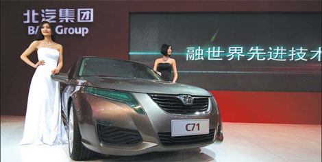 Models pose by a C71 of Beijing Automotive Industry Holdings Corporation at the Beijing auto show.[China Daily]