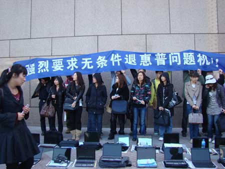 HP laptop users with their defective computers protest outside HP's China headquarters in Beijing Friday. [Global Times]