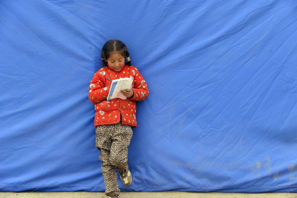 7-year-old Ren Qu of Tibetan ethnic group is solving a mathematical problem during a short break among classes inside the temporary classroom at racecourse Gyegu Town of quake-hit Tibetan Autonomous Prefecture of Yushu, northwest China's Qinghai Province, April 25, 2010.
