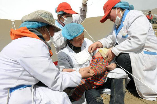 Medical staff of a medical team feed a baby with milk in a bottle in the Tibetan Autonomous Prefecture of Yushu, northwest China's Qinghai Province, April 18, 2010. Medical staff of the medical team sent by Garze County of southwest China's Sichuan Province took the responsibility to take care of a newborn as the baby's parents were severely injured during the fatal earthquake that struck here on early Wednesday.