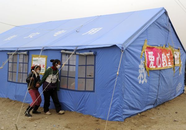 Two children of Tibetan ethnic group look inside the temporary classroom at racecourse Gyegu Town of quake-hit Tibetan Autonomous Prefecture of Yushu, northwest China's Qinghai Province, April 25, 2010. 