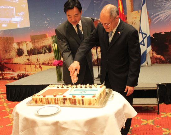 Zhai Jun, Chinese vice foreign minister (left), and Amos Nadai, Israeli ambassador to China, cut a celebration cake at a reception in Beijing to mark Israel's 62nd anniversary and 18 years of Sino-Israeli ties on April 23, 2010. 