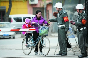 Resident shows ID card to get in the village. [Beijing News]