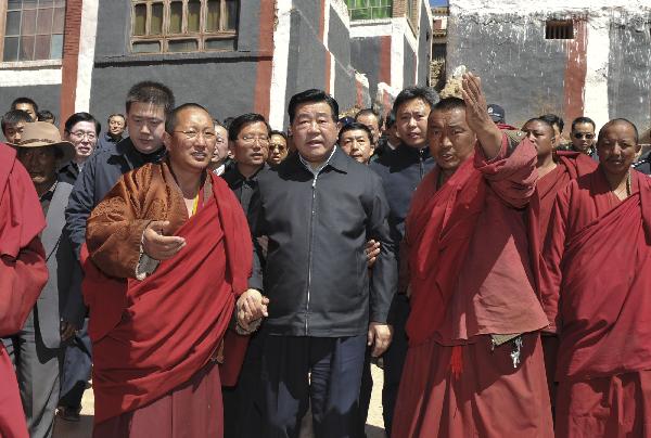 Jia Qinglin (C), chairman of the National Committee of the Chinese People's Political Consultative Conference, visits local monks in quake-hit Yushu County, northwest China's Qinghai Province, on April 26, 2010. 