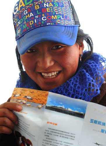 A girl smiles while waiting to board the plane to Xining at the Yushu airport, northwest China's Qinghai province, April 26, 2010.