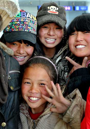Children from the Yushu welfare house pose for photos before boarding the plane to Xining at the Yushu airport, northwest China's Qinghai province, April 26, 2010.