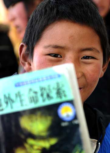 A boy reads a book before boarding the plane to Xining at the Yushu airport, northwest China's Qinghai province, April 26, 2010.