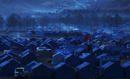 Tents for some 30,000 quake-affected residents are erected as makeshift shelters at a race course in Yushu, Qinghai Province, Monday.