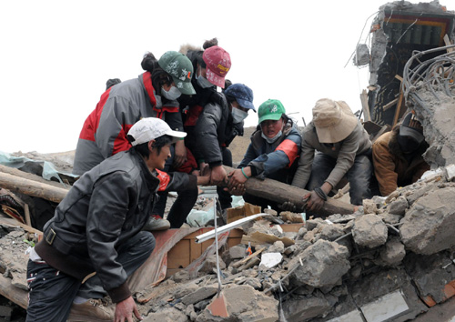 Volunteers clean up house debris in Yushu, Northwest China's Qinghai province on April 21, 2010.
