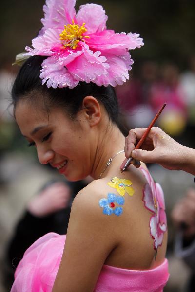 A model has her body painted with colorful patterns during a body painting show at the scenic zone of Yangzigou in Luoyang, Henan Province, April 24, 2010. 