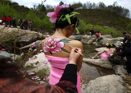 A model has her body painted with colorful patterns during a body painting show at the scenic zone of Yangzigou in Luoyang, Henan Province, April 24, 2010. 